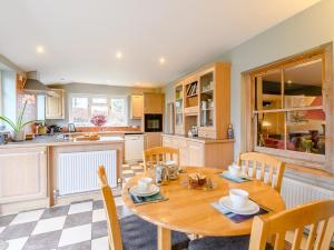 a kitchen and dining room with a wooden table and chairs at 2 Bed in Tiverton 77884 in Bolham