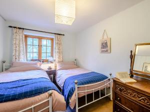 2 Betten in einem Schlafzimmer mit einem Spiegel und einer Kommode in der Unterkunft 2 Bed in Tiverton 77884 in Bolham
