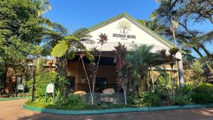 a building with palm trees in front of it at White River Selfcatering at Greenway woods House no 9 in White River