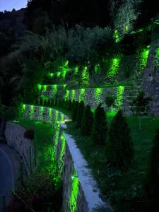 een 's nachts verlichte tuin met groene lichten bij Villa di campagna con vista mare 5 camere da letto in Pampara