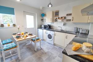 a kitchen with a table and a washing machine at Peedie Picky Townhoose - STL OR00094F in Orkney