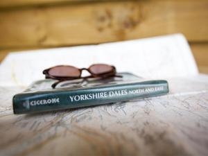 a book with a pair of glasses sitting on a table at 1 Bed in Masham G0089 in Thornton Watlass