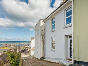a white house with the beach in the background at 3 Bed in Brixham 78602 in Brixham