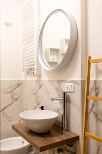 bagno con lavandino bianco e specchio di THE BASEMENT a Milano