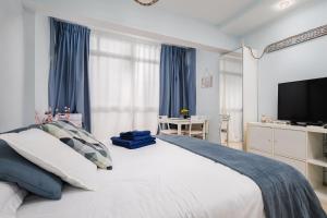sypialnia z dużym łóżkiem z niebieskimi zasłonami w obiekcie Beach House Apartment, Playa Malagueta w Maladze