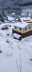 een dorp bedekt met sneeuw met een gebouw bij Chata U dědka in Prostřední Bečva