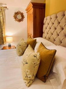 a bedroom with a bed with pillows and a mirror at Wells Cottage in Malvern Wells