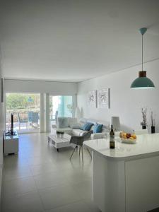 a white living room with a couch and a table at Relax in Reserva del Higuerón - Crystalline in Benalmádena