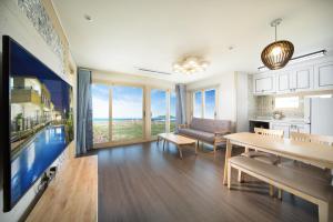 a kitchen and living room with a view of the ocean at Geumdanyoung Pension in Jeju