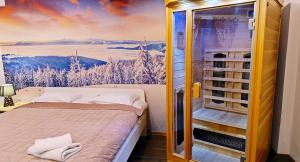 a room with a bed and a window with a winter scene at Villa Vista Apartamenty & SAUNA in Zakopane