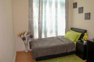 a bedroom with a bed and a large window at Staff Guest House in Nyíregyháza