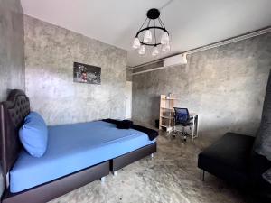 a bedroom with a blue bed and a desk at 4J River Camping and Resort in Phetchaburi