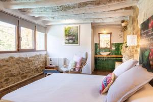 um quarto com uma cama e uma casa de banho com um lavatório em La LUNA Casa rural Vall de Gallinera refugio em Patró