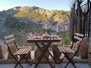 uma mesa de piquenique com duas cadeiras e vista para uma montanha em La LUNA Casa rural Vall de Gallinera refugio em Patró