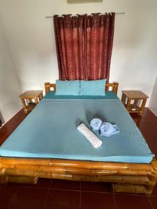 a bed with a blue mattress and two towels on it at Tauig Beach Resort in Moalboal +134 photos