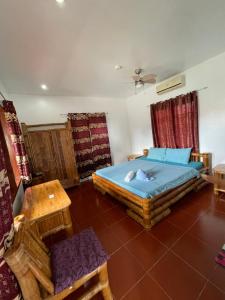 a bedroom with a bed and a table at Tauig Beach Resort in Moalboal