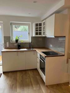 a kitchen with white cabinets and a stove top oven at Chic und gemütlich in Dudenhofen