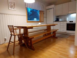 a kitchen with a wooden table and a wooden chair at Tupasvilla in Syöte