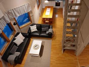 uma sala de estar com um sofá preto e uma mesa em Tupasvilla em Syöte