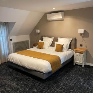 sypialnia z dużym łóżkiem z białą pościelą i poduszkami w obiekcie Le Sainte Jeanne w mieście Cormeilles-en-Vexin