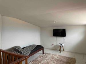 1 dormitorio con 1 cama y TV de pantalla plana en Residencial Vista da Serra en Diamantina