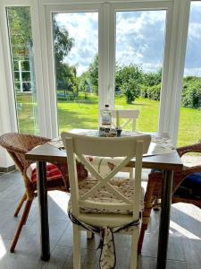 einen weißen Tisch und Stuhl in einem Zimmer mit Fenster in der Unterkunft FerienGut Gaarz - Cottage 29 in Göhl