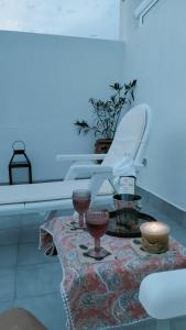 a table with some candles and a white chair at Ático Plaza 9 by casitasconencantoes in Medina Sidonia