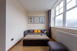 uma sala de estar com um sofá e uma mesa em BOURNECOAST: MODERN FLAT NEAR SHOPS -WIFI-FM6288 em Bournemouth