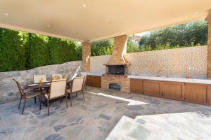an outdoor patio with a table and chairs and a fireplace at Vlasis' Eden Villa in Sálakos