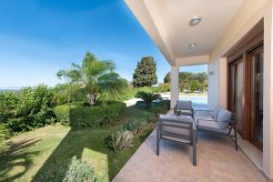 a patio with chairs and a view of the ocean at Vlasis' Eden Villa in Sálakos