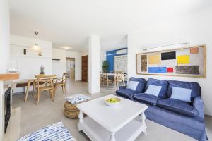 uma sala de estar com um sofá azul e uma mesa em Apartment Blavamar em El Port