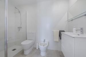 uma casa de banho branca com um WC e um chuveiro em Apartment Blavamar em El Port