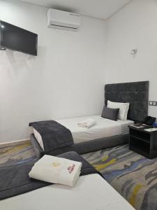 מיטה או מיטות בחדר ב-فندق الشموخ Hotel Al Shmokh