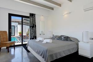 een witte slaapkamer met een bed met handdoeken erop bij Villa Marcelino in Port de Pollença +12 foto's