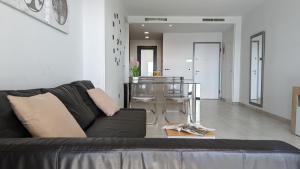 uma sala de estar com um sofá preto e um bar em SUNSET WAVES lovely apartment em Benidorm