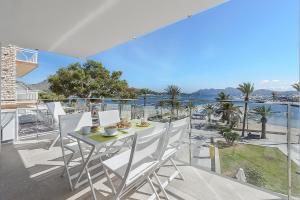 a table and chairs on a balcony with a view of the water at Apartment Roqueta in Pollença