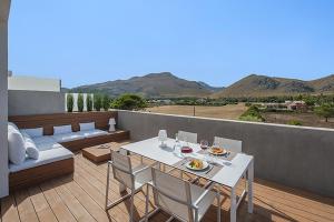 ein Balkon mit Tisch und Stühlen und Bergen in der Unterkunft Penthouse Dalias in Port de Pollença