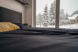 Schlafzimmer mit einem Bett und einem Fenster mit Schnee in der Unterkunft black well in Jablonec nad Nisou