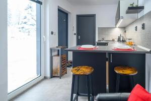 eine Küche mit einer Theke mit zwei Stühlen in der Unterkunft black well in Jablonec nad Nisou