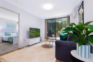 a living room with a blue couch and a tv at Crows Nest Gem - with parking in Sydney