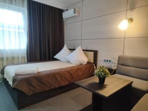 a hotel room with a bed and a table at Отель Бестау in Aksay