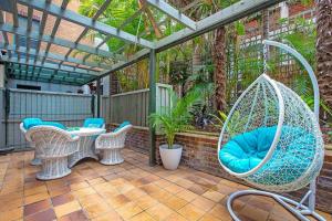 patio z huśtawką, krzesłami i stołem w obiekcie Crows Nest Gem - with parking w mieście Sydney