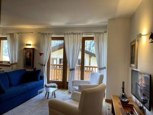 a living room with a blue couch and chairs at Appartamento Chalet a Pinzolo in Pinzolo