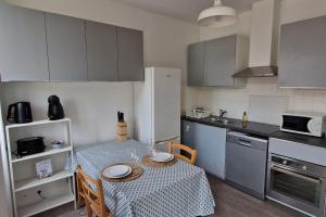 a small kitchen with a table and a table and chairs at Le Cocon Margalais in Margaux