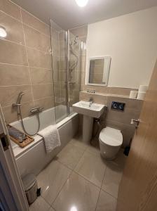 a bathroom with a toilet and a sink and a shower at 3 Bed Home for Contractors Relocators with Parking Garden WiFi Sleeps 6 in Milton Keynes