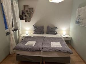 ein Schlafzimmer mit einem Bett mit zwei Handtüchern darauf in der Unterkunft Minimalharmony Apartment in Hannover