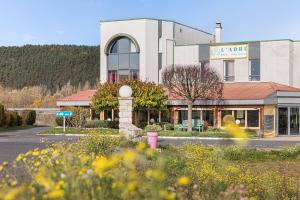 un bâtiment avec un panneau sur le côté d'une route dans l'établissement Hotel L'Abri, au Puy-en-Velay