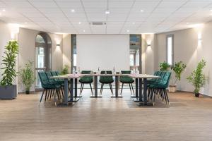 une salle de conférence avec une grande table et des chaises dans l'établissement Hotel L'Abri, au Puy-en-Velay