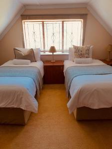 um quarto no sótão com 2 camas e uma janela em Khutsong Lodge 