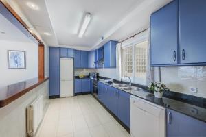uma cozinha azul com um lavatório e armários azuis em Apartment Vistamar IV em Port de Pollença